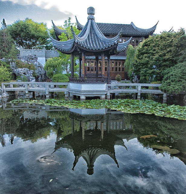 Classical pavilion reflected in lily pond